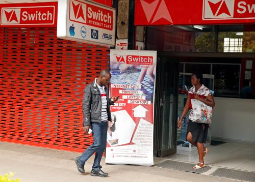 A man checks his mobile phone outside an internet cafe in Harare, Zimbabwe, January 21, 2019. REUTERS/Philimon Bulawayo