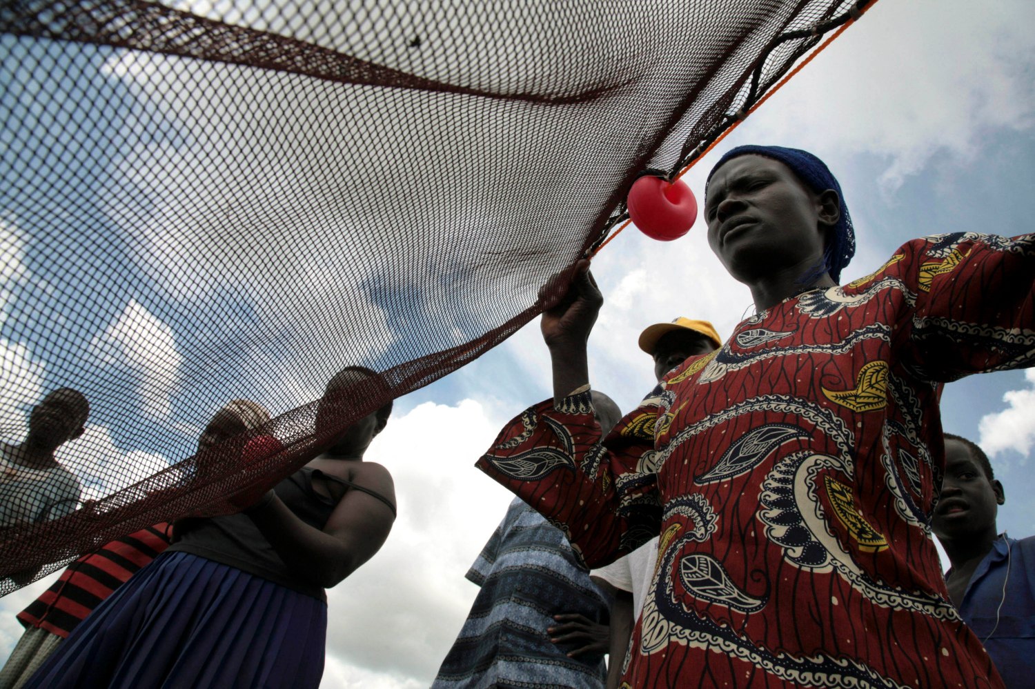 Women prepare to cast a net at a community fish farm project east of Lira in northern Uganda July 28, 2007. The Samaritan's Purse/WFP started the project after some 450,000 ethnic Langi displaced into camps by the Lord's Resistance Army returned home in the last 18 months, according to UNHCR. REUTERS/Euan Denholm (UGANDA)