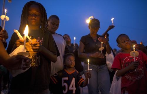 People gather for a candlelight vigil against gun violence in the Englewood neighborhood in Chicago, Illinois, United States, July 3, 2015. Extra police patrols and long shifts were not enough to prevent nine deaths and about 50 injuries from gun violence in Chicago over the Fourth of July weekend, when homicides jump almost every year. Chicago, with 2.7 million people, is the most violent large city in the United States, with poverty, segregation, dozens of small street gangs, and a pervasive gun culture all contributing to the problem. Picture taken July 3, 2015.   REUTERS/Jim Young