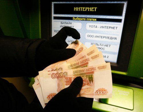 A client counts 5,000-rouble banknotes while using an ATM bank machine at a branch of Sberbank in the Siberian city of Krasnoyarsk, Russia, January 11, 2016. Russia's rouble fell further on January 20, setting a new record low of over 81 roubles per dollar as a bearish mood gripped Russian financial markets. Picture taken January 11, 2016. REUTERS/Ilya Naymushin