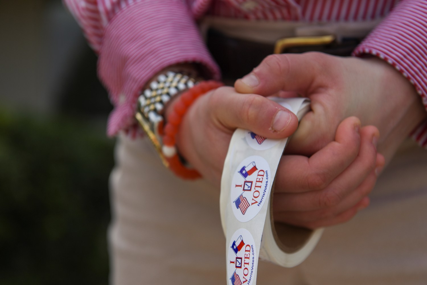 A woman passes out stickers as voters cast their ballot in the Democratic primary election at a polling station in Houston, Texas, U.S. March 3, 2020.  REUTERS/Callaghan O'Hare