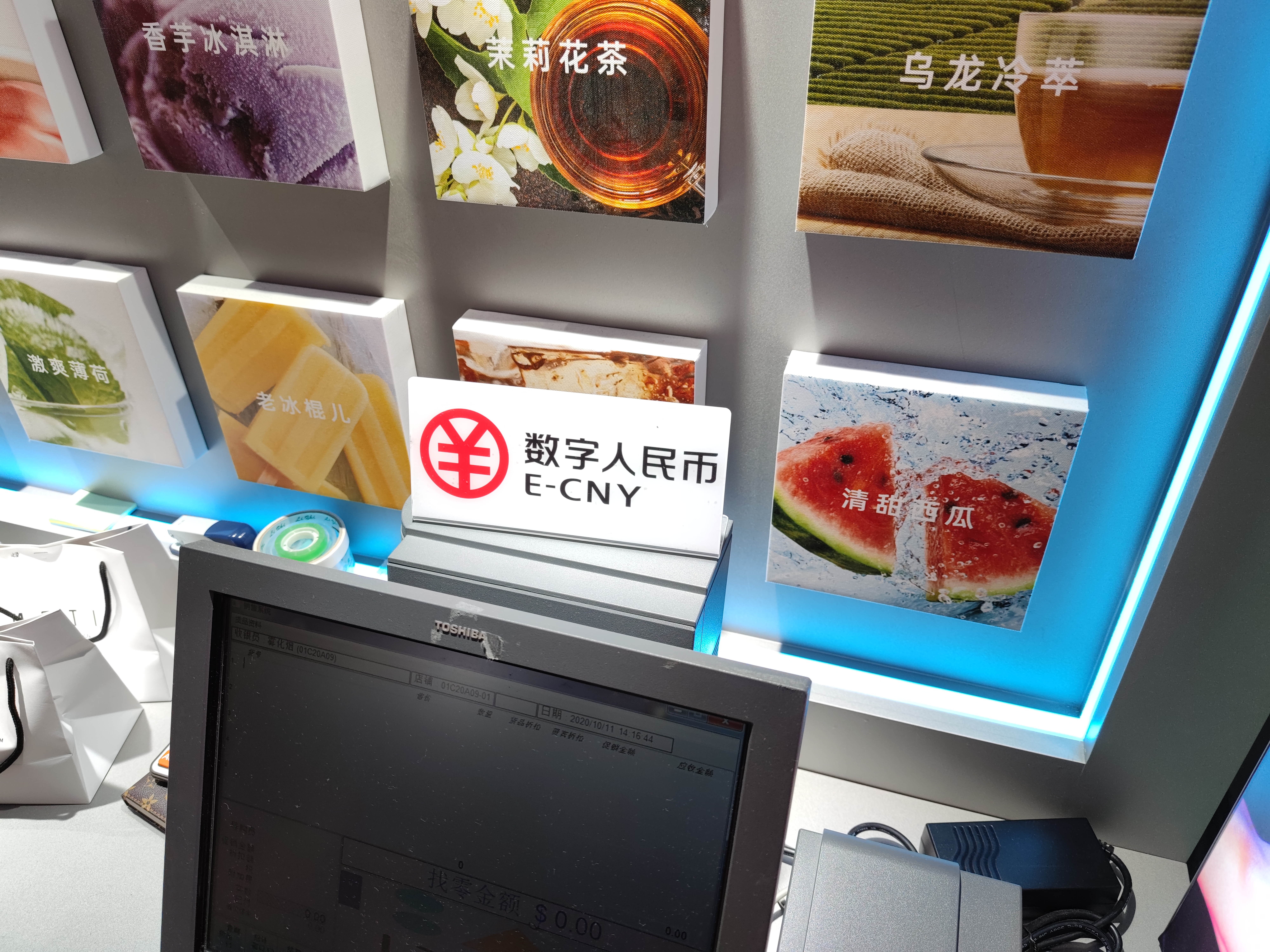 An E-CNY payment sign is put up on a desk in a store in the Luohu District in Shenzhen city, south China's Guangdong province, 11 October 2020.The Shenzhen municipal government announced a giveaway of ten million renminbi ($1.5 million) in central bank digital currency (CBDC). Fifty thousand people would receive the gifted money on a lottery basis in amounts of 200 yuan as part of the digital yuan tests and the trial was in the Luohu District. In accordance with the trial, about 3389 shops including restaurants and retail stores had updated and equiped system allowing eCNY payment in the Luohu District. As of 8p.m. on 11th October 2020, over 1.91million people participated in the lottery winning.No Use China. No Use France.