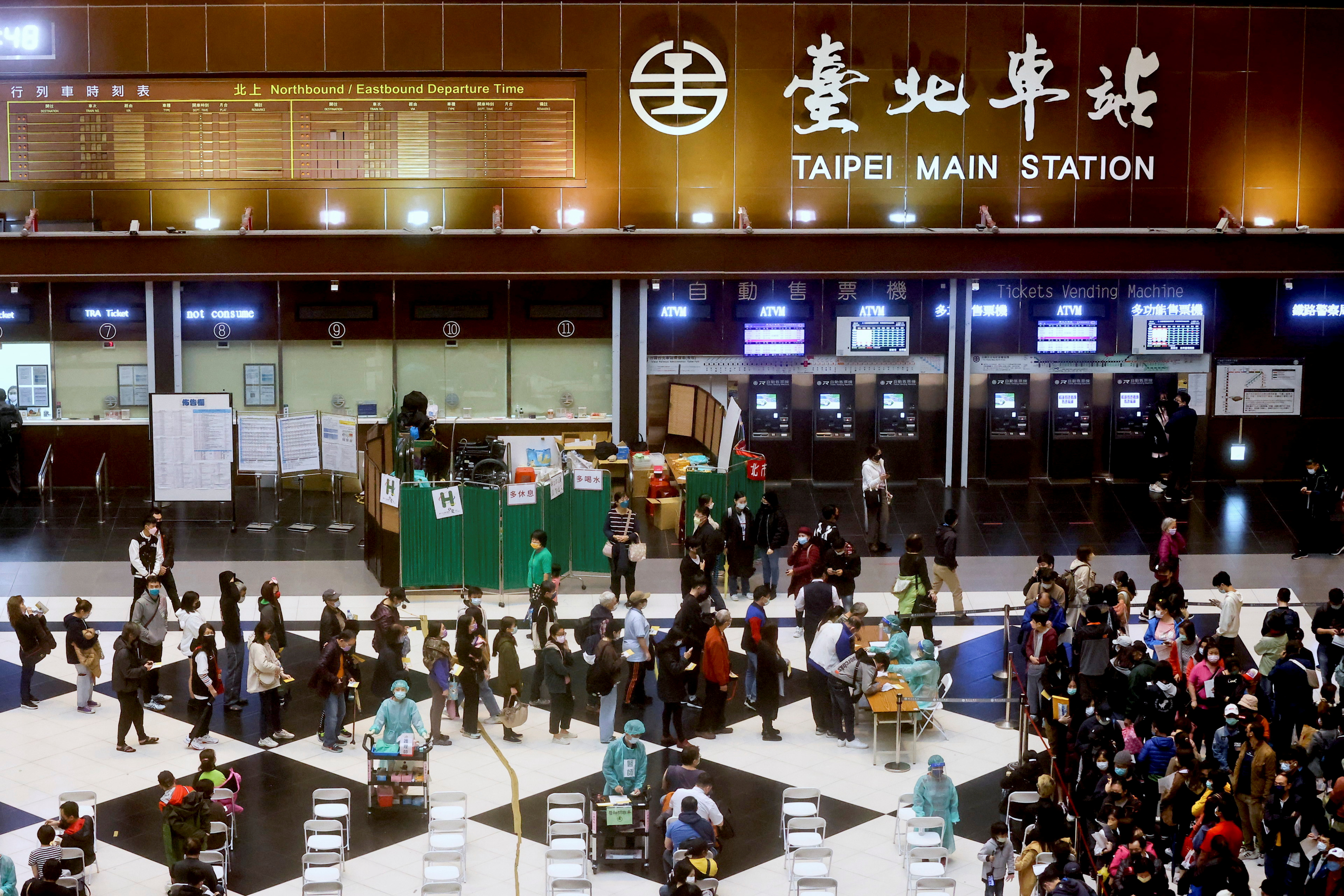 People wait to receive their booster shot of the coronavirus disease (COVID-19) vaccine at the lobby of Taipei main station ahead of Lunar new year in Taipei, Taiwan, January 24, 2022. REUTERS/Ann Wang