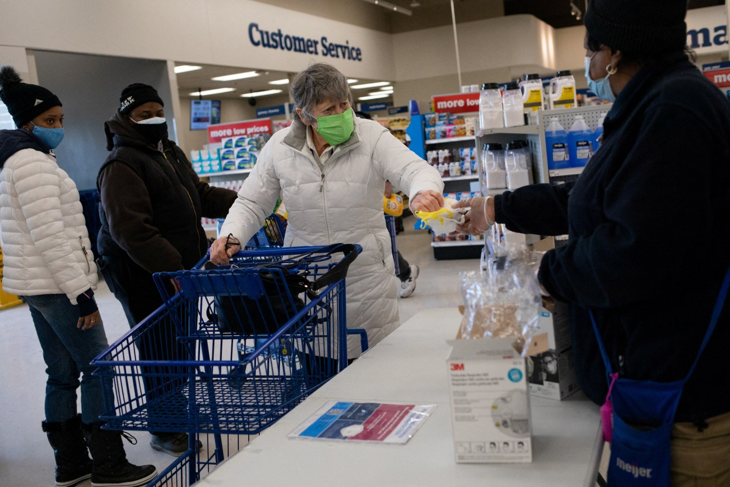 People receive three free N95 masks as part of a government strategy to reduce the spread of coronavirus disease (COVID-19) at Meijer in Southfield, Michigan, U.S., January 25, 2022.  REUTERS/Emily Elconin