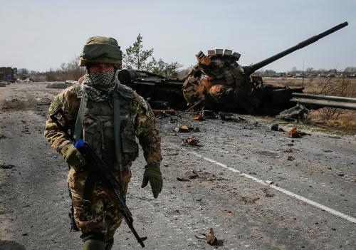 A Ukrainian serviceman walks near the wreck of a Russian tank on the front line in the Kyiv region, Ukraine March 28, 2022. REUTERS/Gleb Garanich