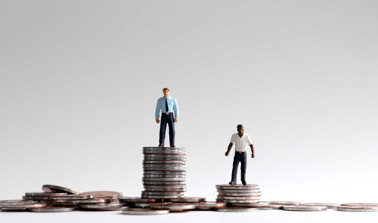Toy figures standing on stacks of coins.