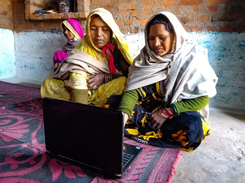 Two woman use a computer to request government services.
