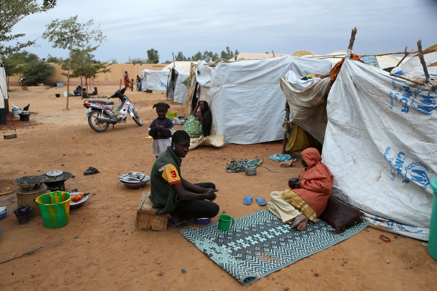 Individuals sit outside tent in Mali.