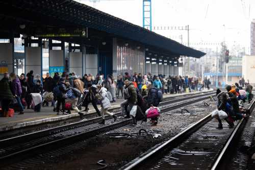 People cross the railways as they try to catch an evacuation train at Kyiv central train station, Ukraine, on March 2, 2022. On the seventh day of Russia invading Ukraine. Photo by Raphael Lafargue/ABACAPRESS.COM