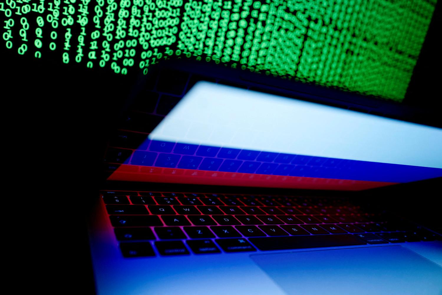 FILE PHOTO: A Russian flag is seen on the laptop screen in front of a computer screen on which cyber code is displayed, in this illustration picture taken March 2, 2018. REUTERS/Kacper Pempel/Illustration/File Photo