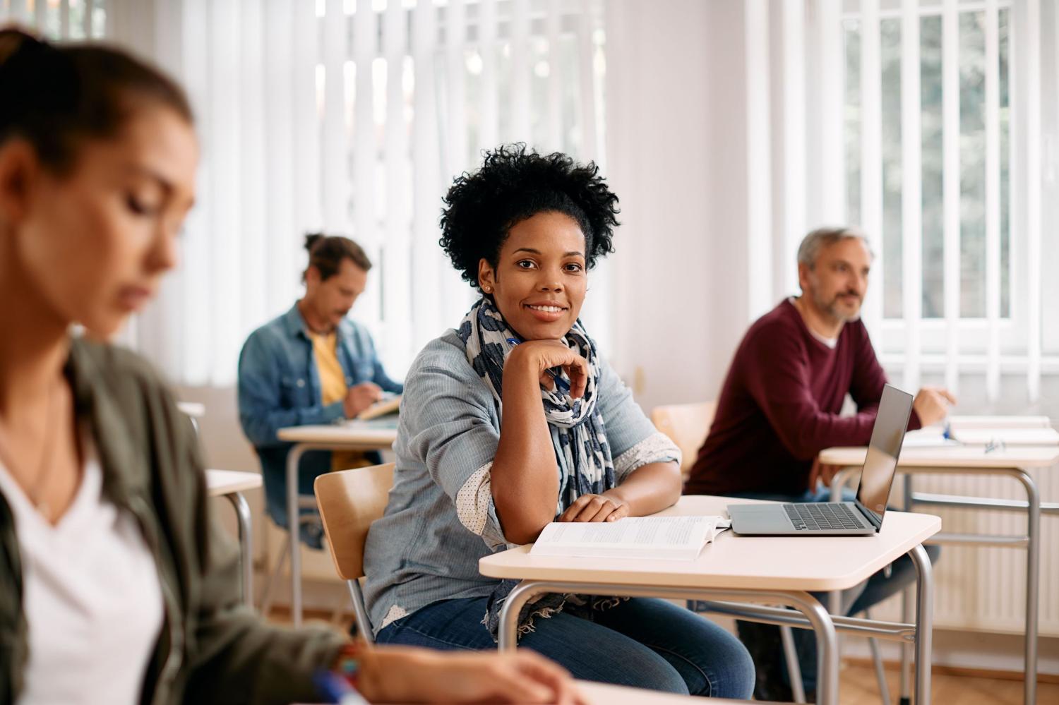 Adult students sitting at desks in classroom.