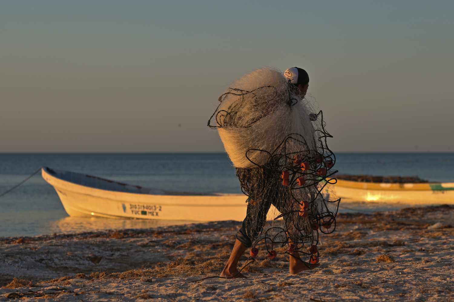A local fisherman carries nets as preparing his fishing boat on the beach of Celestun.On Tuesday, February 22, 2022, in Celestun, Yucatan, Mexico. (Photo by Artur Widak/NurPhoto)NO USE FRANCE