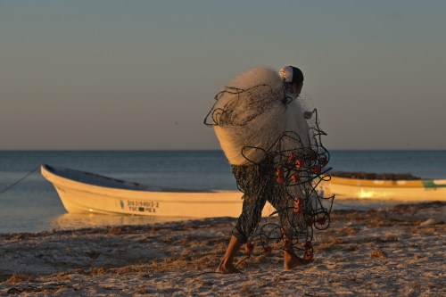 A local fisherman carries nets as preparing his fishing boat on the beach of Celestun.On Tuesday, February 22, 2022, in Celestun, Yucatan, Mexico. (Photo by Artur Widak/NurPhoto)NO USE FRANCE