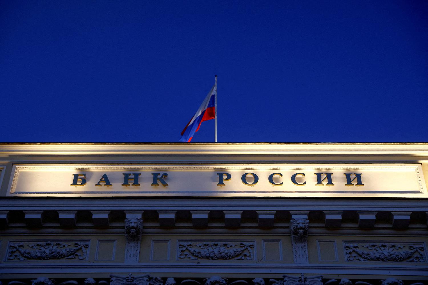 FILE PHOTO: A Russian state flag flies over the Central Bank headquarters in Moscow, Russia March 29, 2021. A sign reads: "Bank of Russia". REUTERS/Maxim Shemetov/File Photo
