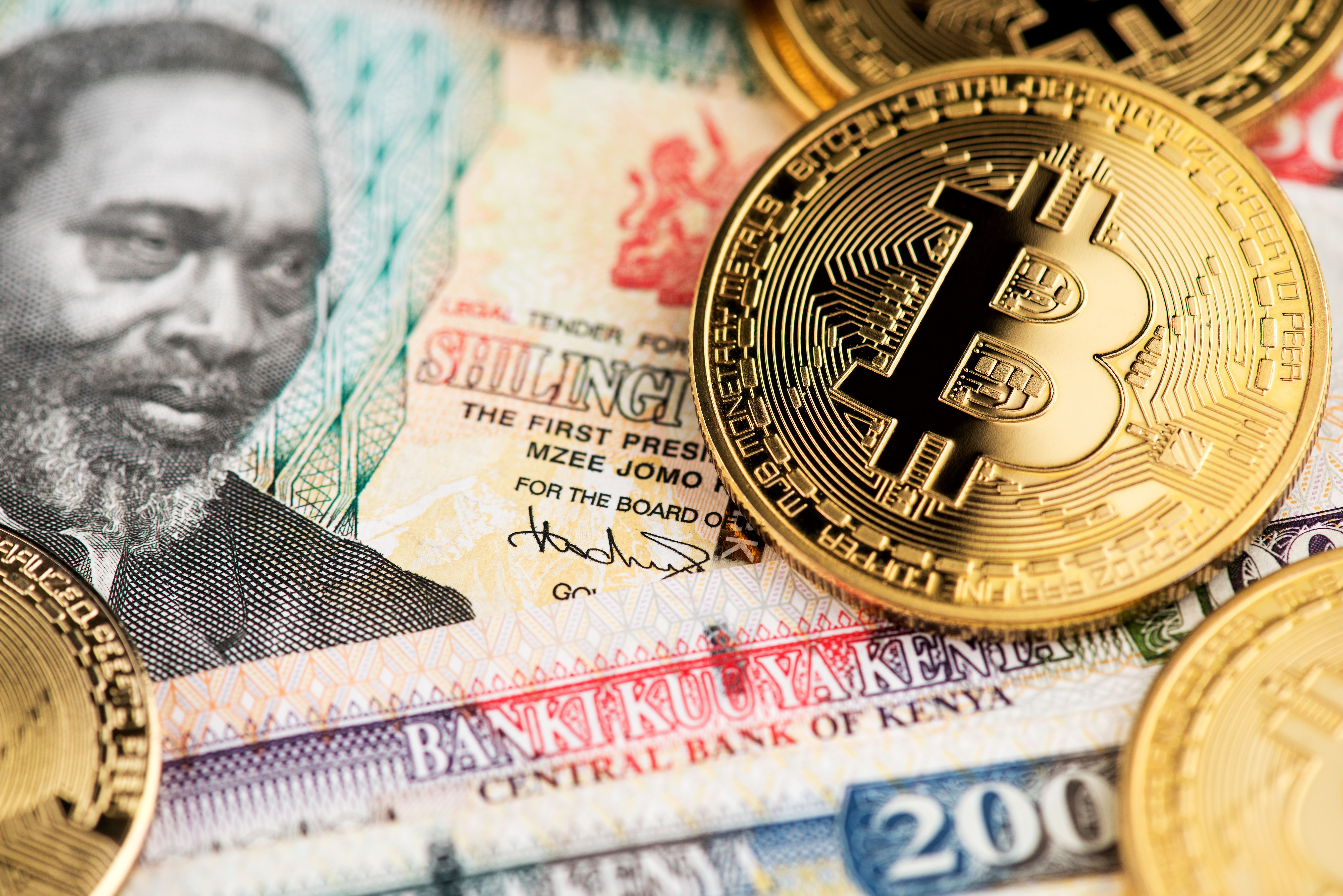 Kenyan Shilling Banknotes and Bitcoin Cryptocurrency coins close up image