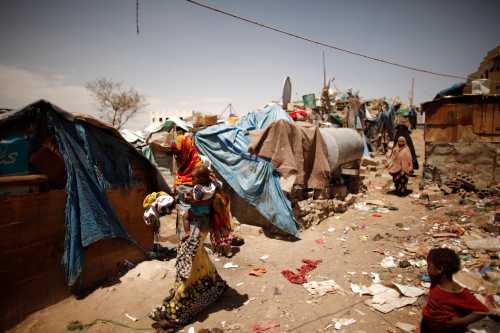 A woman carries her son as she walks in a slum area in Sanaa, Yemen.