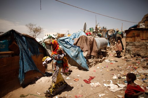 A woman carries her son as she walks in a slum area in Sanaa, Yemen.