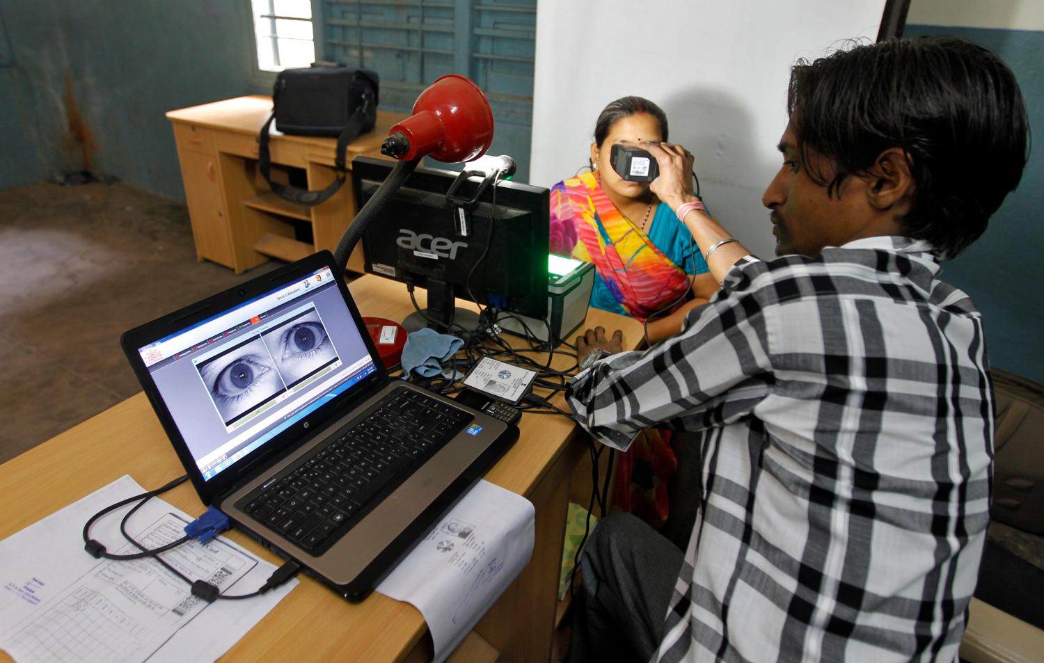 A woman goes through the process of eye scanning for Unique Identification (UID) database system in the outskirts of the western Indian city of Ahmedabad February 13, 2013. The UID database, known as Aadhaar, will help directly transfer budget-busting subsidies to the poor, plugging in leakages in welfare spending. Picture taken February 13, 2013.    To match INDIA-BUDGET/     REUTERS/Amit Dave (INDIA - Tags: BUSINESS SOCIETY)