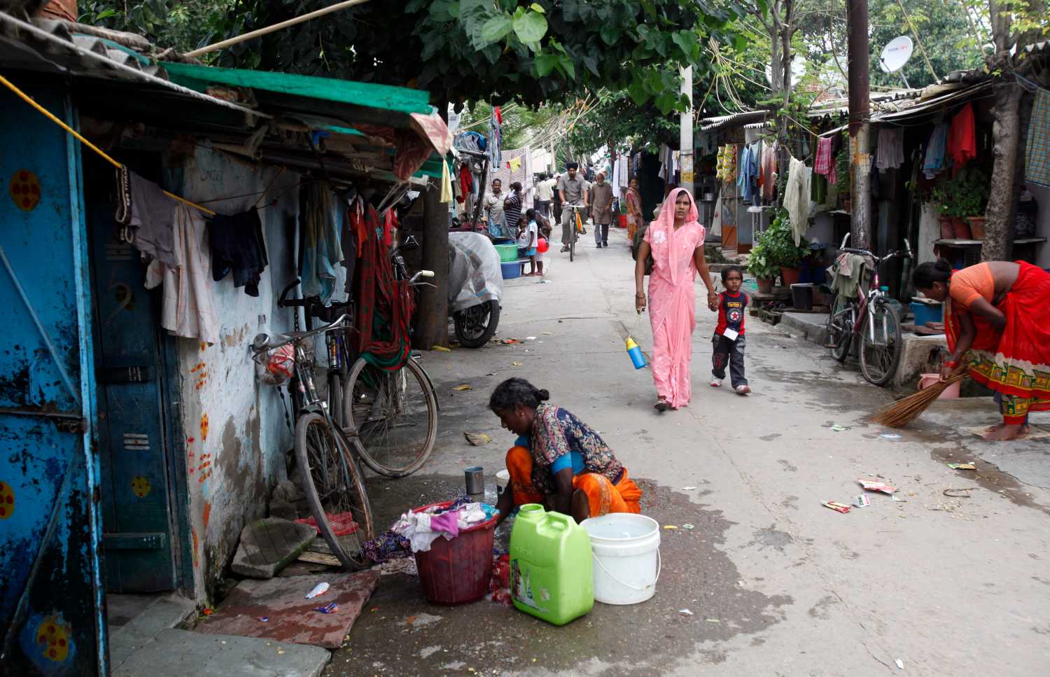 A woman washes clothes outside her house at a slum in New Delhi, India.