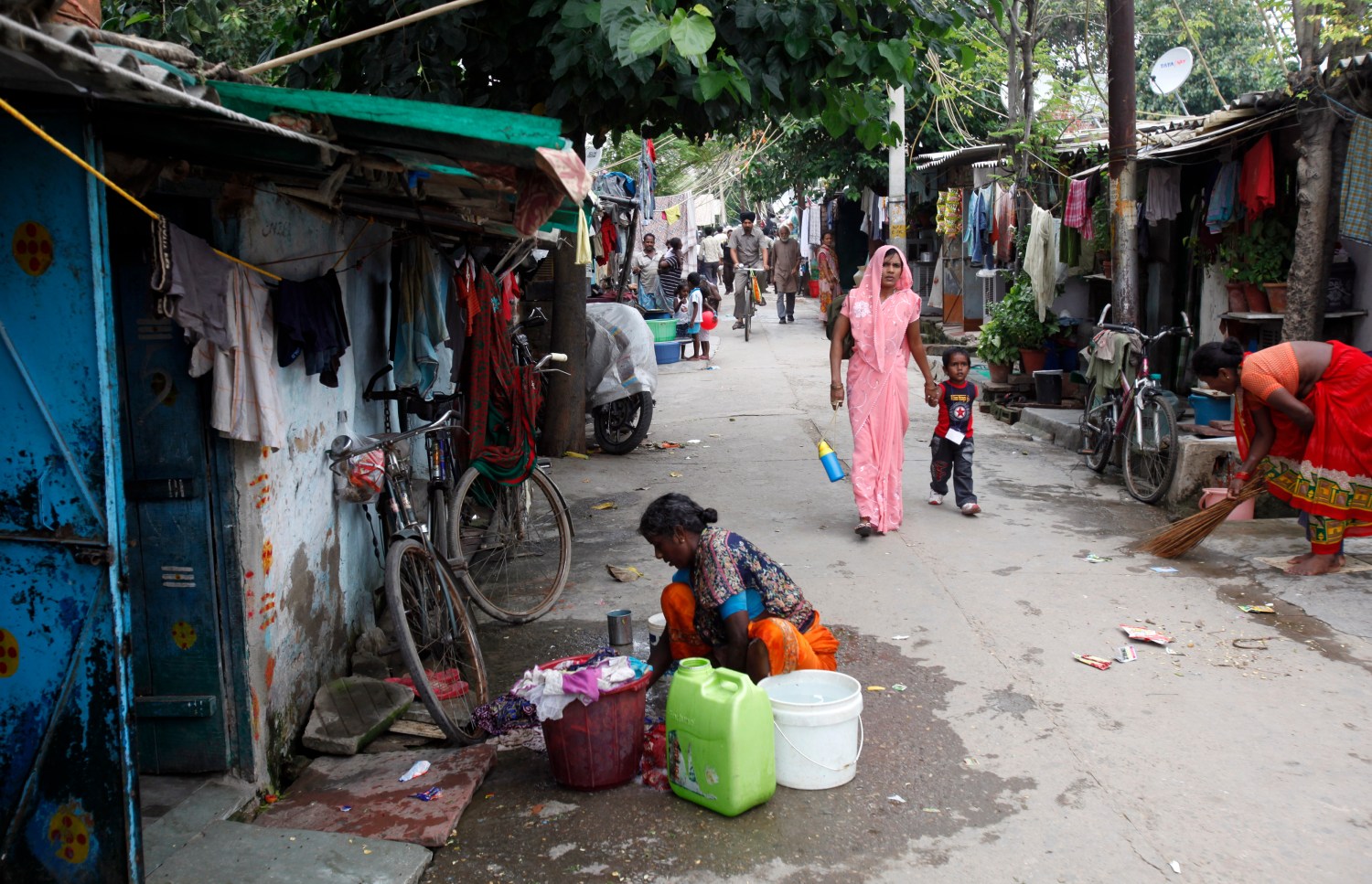 A woman washes clothes outside her house at a slum in New Delhi, India.