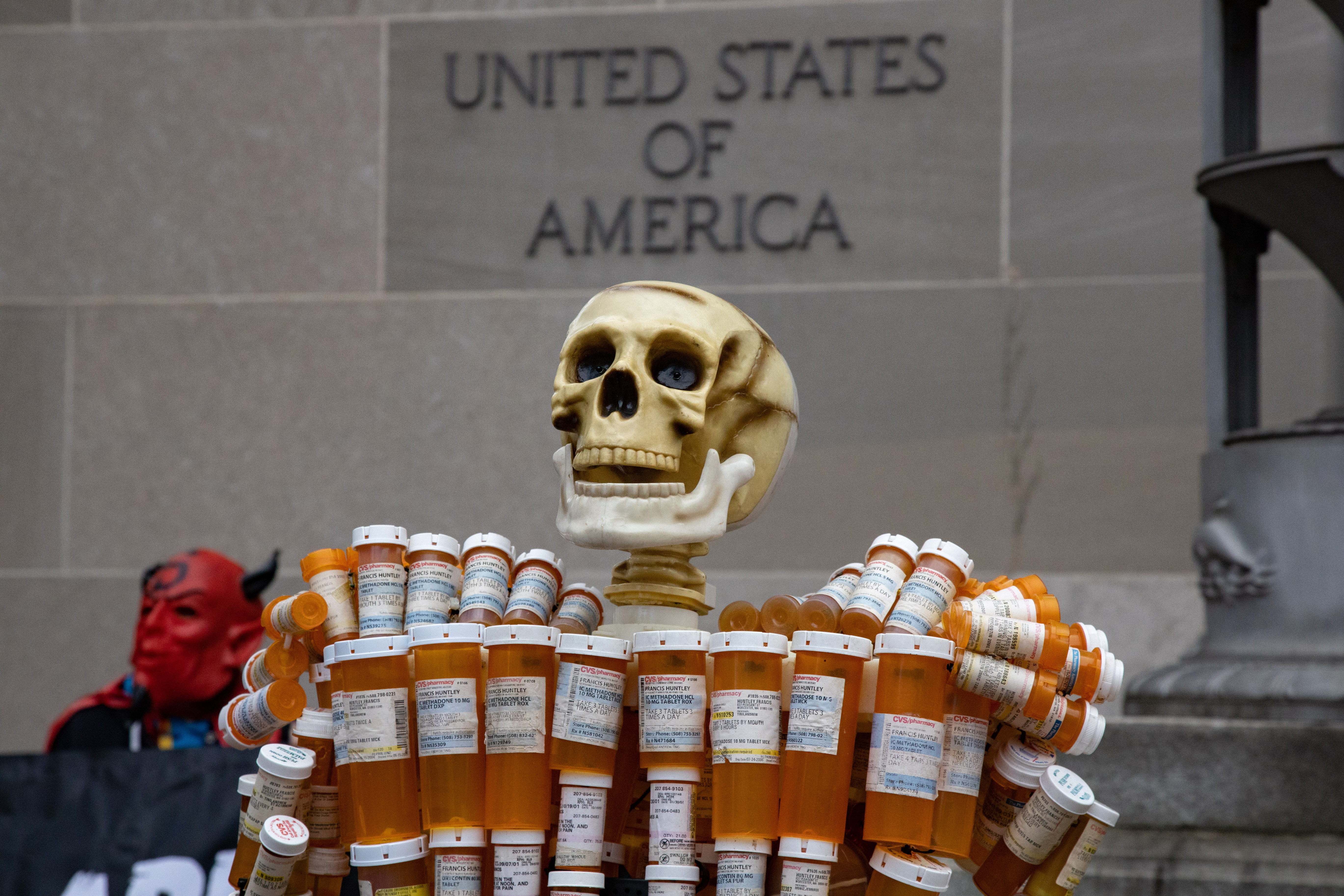 A sculpture created by Frank Huntley, also known as the "Pill Man", stands in front of the Department of Justice building in Washington, D.C. on December 3, 2021 during a protest.