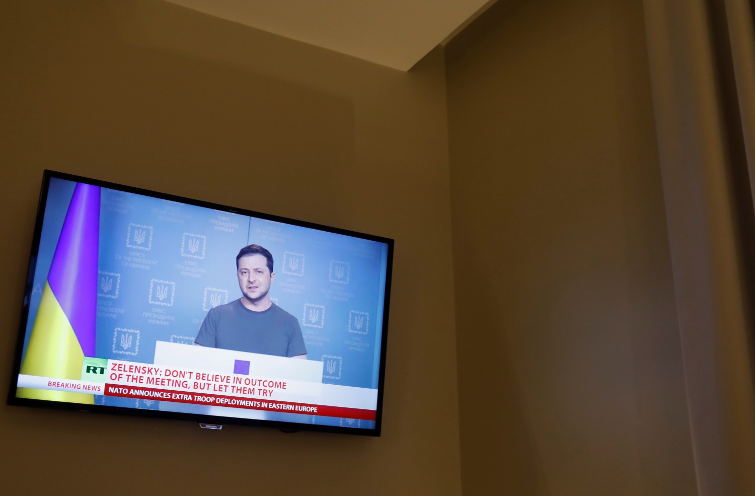 Ukrainian President Volodymyr Zelenskiy is seen on a TV screen in a hotel during a live news broadcast of the Russia Today (RT) channel TV