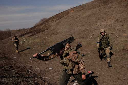A Ukrainian soldier carries Russian weapons captured during a battle between Ukrainian and Russian forces outside Kharkiv, as Russia's attack on Ukraine continues, Ukraine, March 29, 2022.  REUTERS/Thomas Peter/File Photo