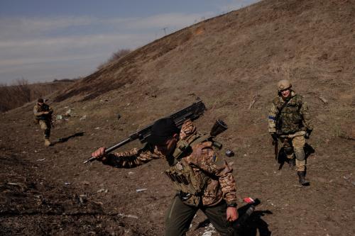 A Ukrainian soldier carries Russian weapons captured during a battle between Ukrainian and Russian forces outside Kharkiv, as Russia's attack on Ukraine continues, Ukraine, March 29, 2022.  REUTERS/Thomas Peter/File Photo