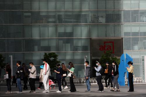 People wearing face masks line up to enter an office building during morning rush hour, following the coronavirus disease (COVID-19) outbreak, in Beijing, China April 26, 2022. REUTERS/Tingshu Wang