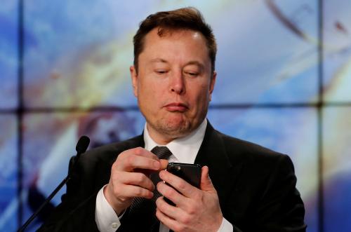 Musk looks at phone