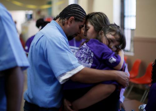 Jessica (C), 28, says goodbye to Abel, 32, as she holds their five-year-old daughter Camila at San Quentin state prison in San Quentin, California June 8, 2012. An annual Fathers' Day event, "Get On The Bus" brings children in California to visit their fathers in prison. Sixty percent of parents in state prison report being held over 100 miles (161 km) from their children. Regular prison visits lower rates of recidivism for the parent, and make the child better emotionally adjusted and less likely to become delinquent, according to The Center for Restorative Justice Works, the non-profit organization that runs the "Get on the Bus" program. Picture taken June 8, 2012.     REUTERS/Lucy Nicholson (UNITED STATES - Tags: CRIME LAW SOCIETY)