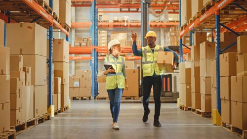 retail workers in a warehouse in conversation.