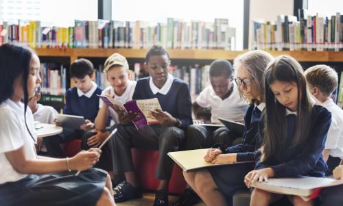 Diverse children reading together at school.