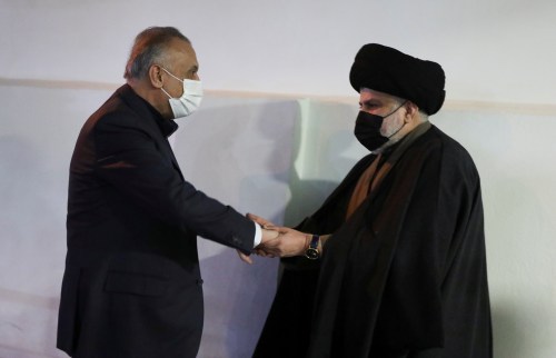 Iraqi Shi'ite cleric Muqtada al-Sadr shake hands with Iraqi Prime Minister Mustafa al-Kadhimi in Najaf, Iraq January 6, 2022. REUTERS/Alaa Al-Marjani