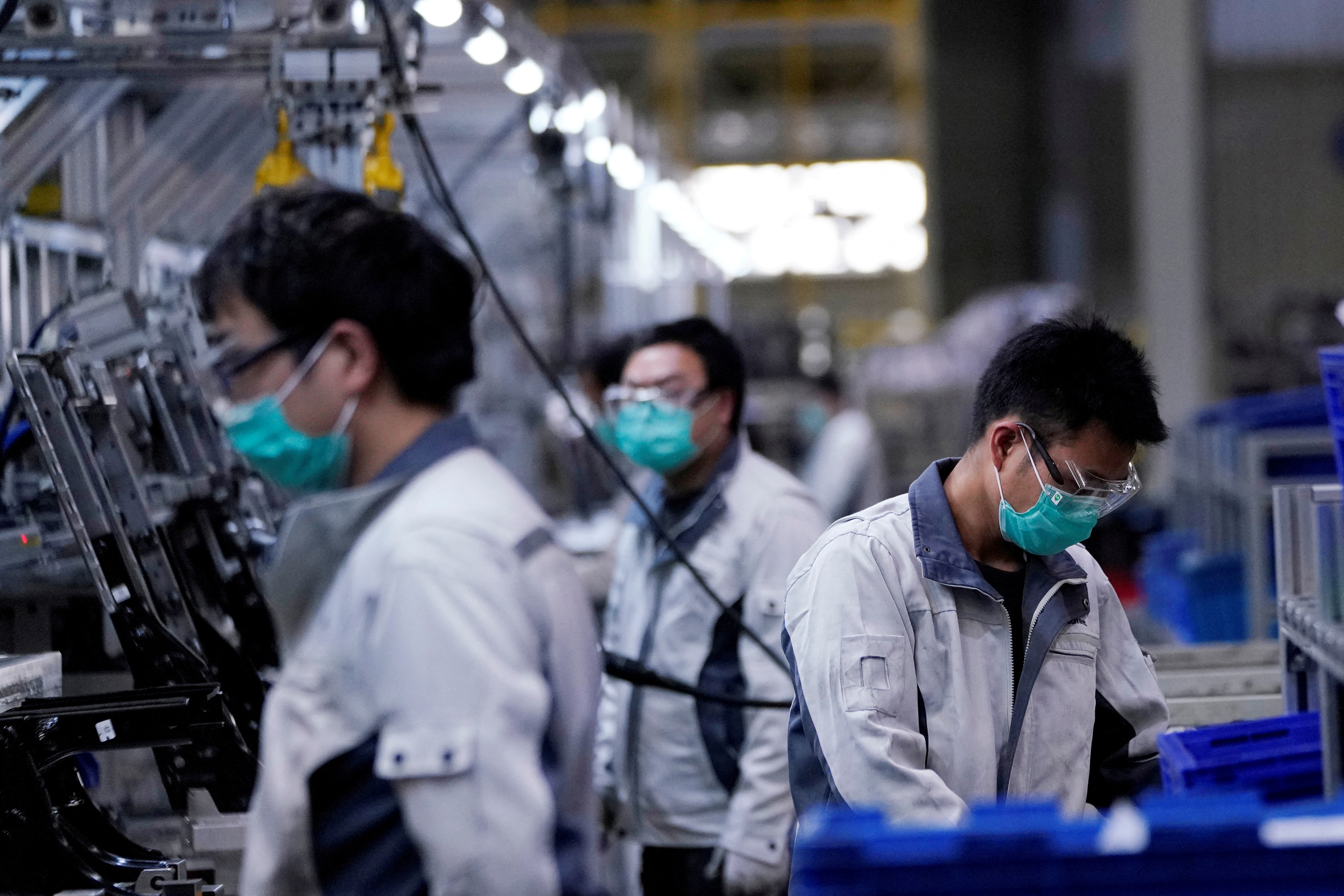 FILE PHOTO: Employees wearing face masks work on a car seat assembly line at Yanfeng Adient factory in Shanghai, China, as the country is hit by an outbreak of a new coronavirus, February 24, 2020. REUTERS/Aly Song/File Photo