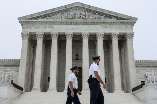 Police officers walk outside the U.S. Supreme Court after the leak of a draft majority opinion written by Justice Samuel Alito preparing for a majority of the court to overturn the landmark Roe v. Wade abortion-rights decision later this year, in Washington, U.S., May 3, 2022. REUTERS/Evelyn Hockstein