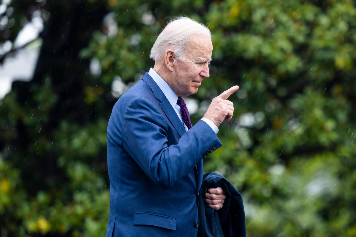 US President Joe Biden points out of frame