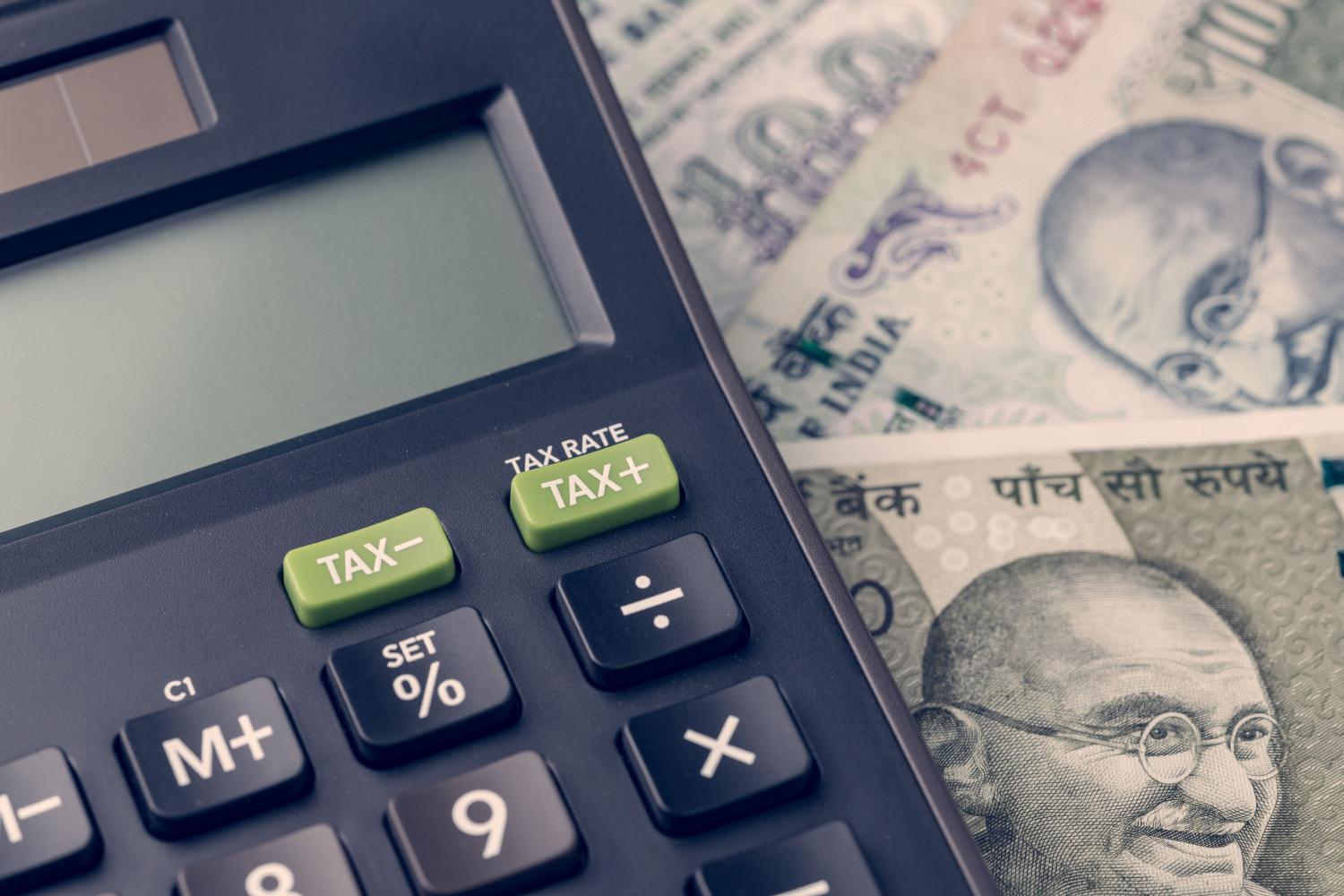 Close-up of calculator on Indian rupee banknotes on table.