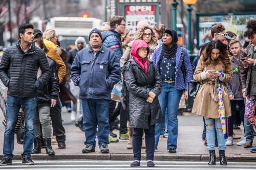 Busy New York City street scene of diversity of pedestrian people crossing the street in Midtown Manhattan on 34th Street Herald Square.