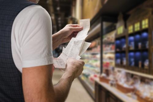 woman looking at receipt in grocery store