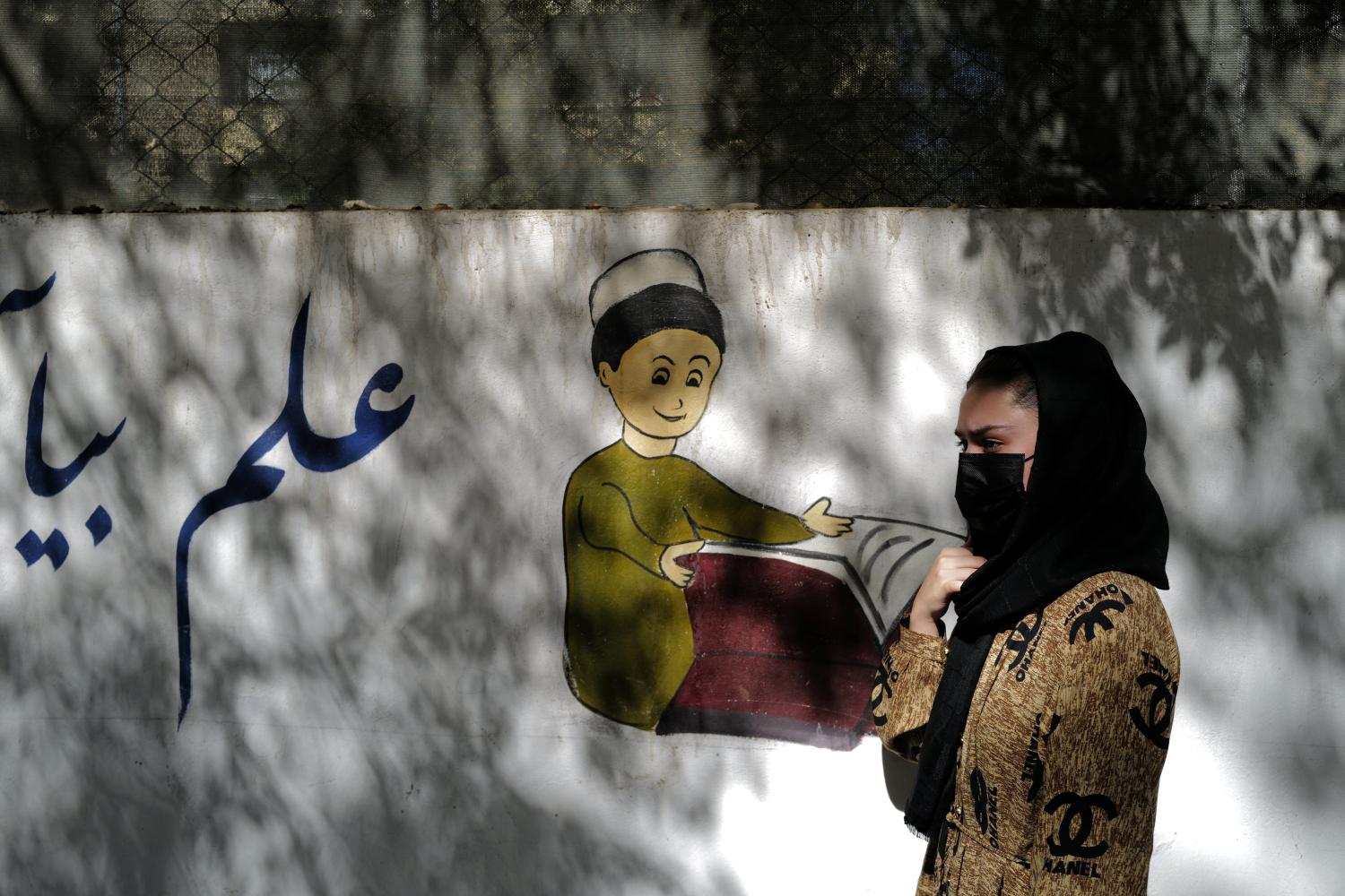 Sahar, 17, an 11th grade secondary school student, walks past her former school in Kabul, Afghanistan, October 20, 2021. Sahar wants to become an engineer, but, for now at least, has to learn at home as best she can. "I would love to come back to my class, resume my studies, to be with my classmates and teachers,"   REUTERS/Zohra Bensemra    SEARCH "BENSEMRA EDUCATION" FOR THIS STORY. SEARCH "WIDER IMAGE" FOR ALL STORIES