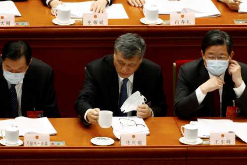 Ma Xingrui, party secretary of Xinjiang Uyghur Autonomous Region, holds a cup as he attends the second plenary session of the National People's Congress (NPC) at the Great Hall of the People in Beijing, China March 8, 2022. REUTERS/Carlos Garcia Rawlins