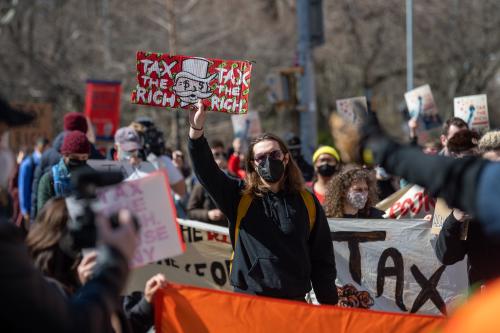 Protest with signs that read "Tax the rich"