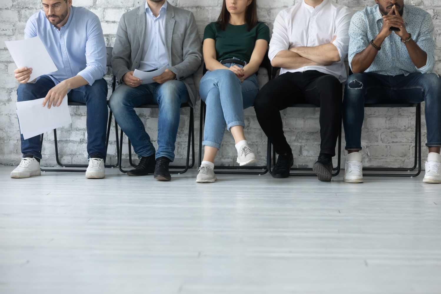 Close up of job candidates sitting in chairs waiting