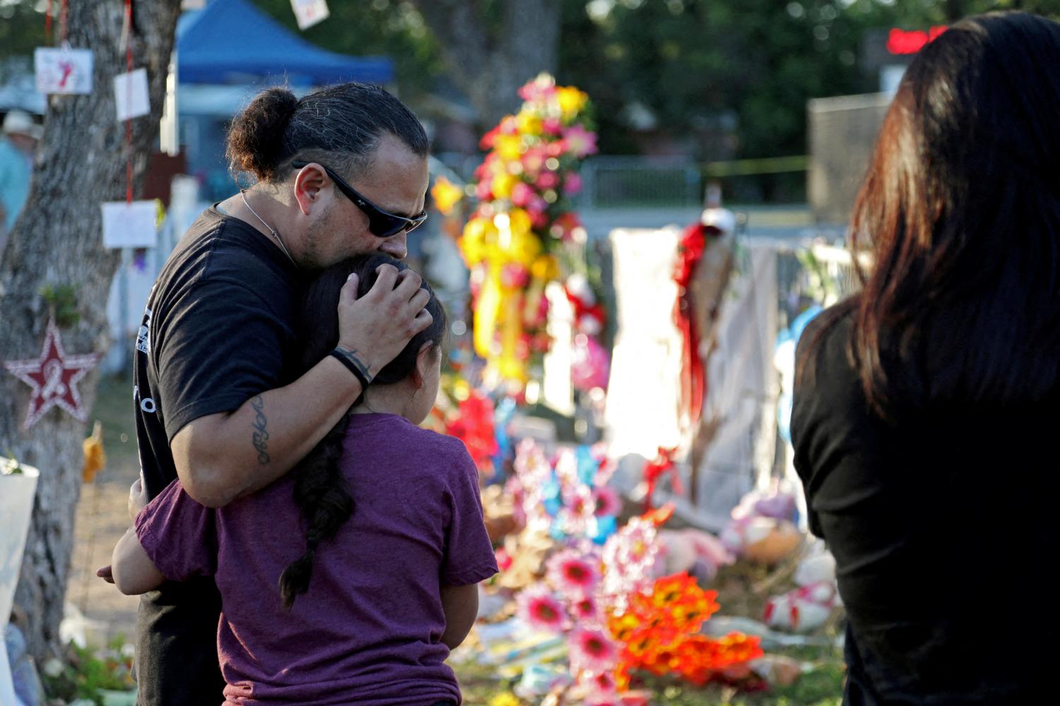 Rudy Ayala of El Paso embraces his daughter Sophia Ayala, 10, as they visit the memorial for the victims of the shooting outside Robb Elementary School early Saturday morning in Uvalde, Texas, U.S., June 11, 2022.    REUTERS/Lisa Krantz       NO RESALES. NO ARCHIVES.