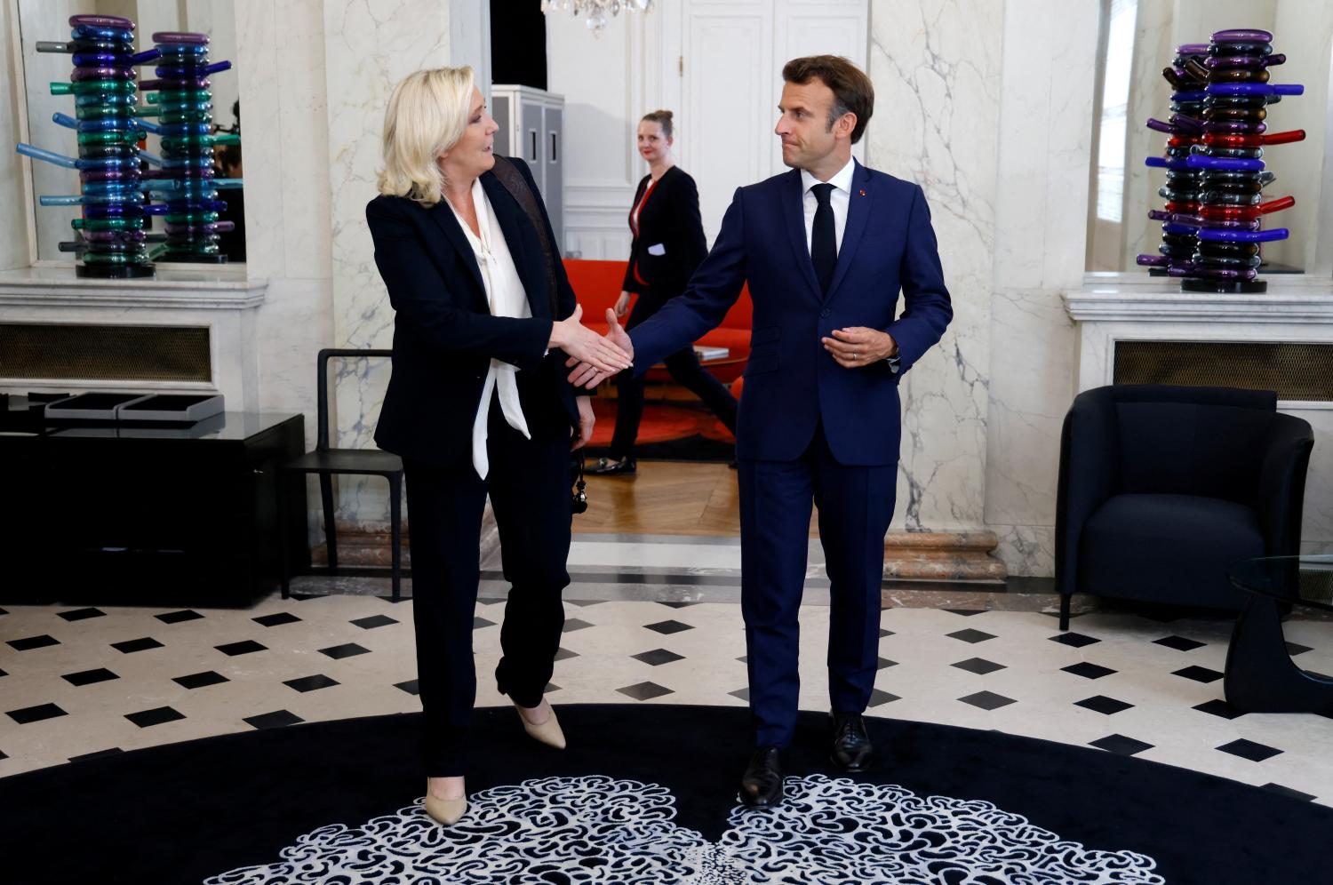 French far-right Rassemblement National (RN) leader and Member of Parliament Marine Le Pen is escorted by France's President Emmanuel Macron after talks at the presidential Elysee Palace, France, June 21, 2022. Ludovic Marin/Pool via REUTERS