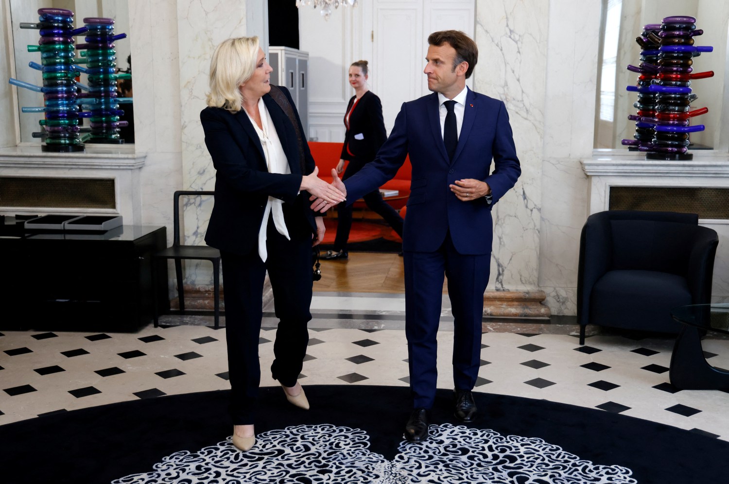 French far-right Rassemblement National (RN) leader and Member of Parliament Marine Le Pen is escorted by France's President Emmanuel Macron after talks at the presidential Elysee Palace, France, June 21, 2022. Ludovic Marin/Pool via REUTERS