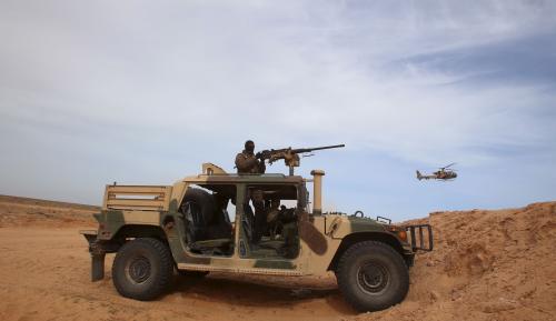 A Tunisian soldier holds his position during an exercise along the frontier with Libya in Sabkeht Alyun, Tunisia February 6, 2016. Tunisia has completed a 200-km (125 mile) barrier along its frontier with Libya to try to keep out Islamist militants, and will soon install electronic monitoring systems, Defence Minister Farhat Hachani said on Saturday. REUTERS/Zoubeir Souissi      TPX IMAGES OF THE DAY