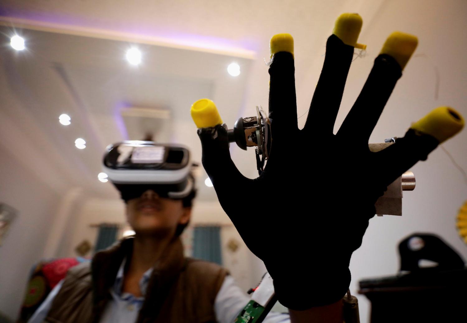 Omar Wael, a 13-year-old Egyptian developer, uses a virtual reality (VR) device as he works at his home in Alexandria, Egypt, May 23, 2022. Picture taken May 23, 2022. REUTERS/Mohamed Abd El Ghany