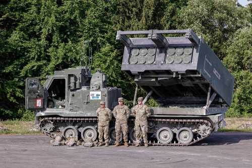 U.S. soldiers stand in front of the Multiple Rocket Launch System (MRLS) during a U.S. Army multinational artillery fire exercise involving nearly 2,400 soldiers from 19 nations at Grafenwoehr Training Area in Bavaria, Germany.